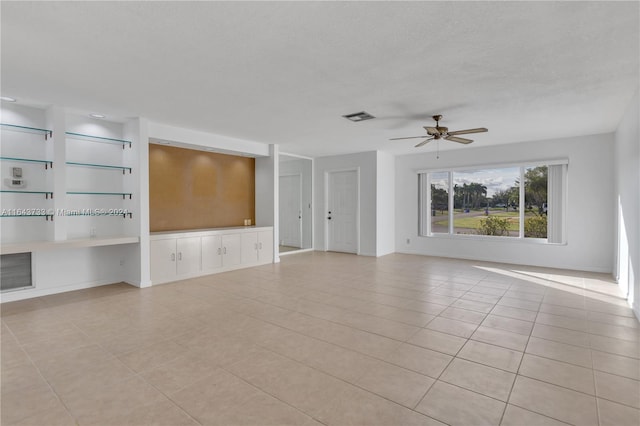 unfurnished living room with ceiling fan and light tile patterned floors