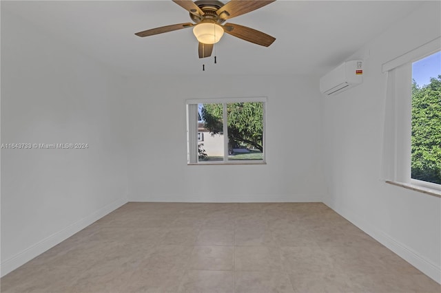 tiled spare room featuring ceiling fan, plenty of natural light, and a wall unit AC