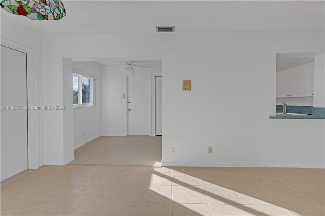 spare room with ceiling fan, sink, and light tile patterned floors