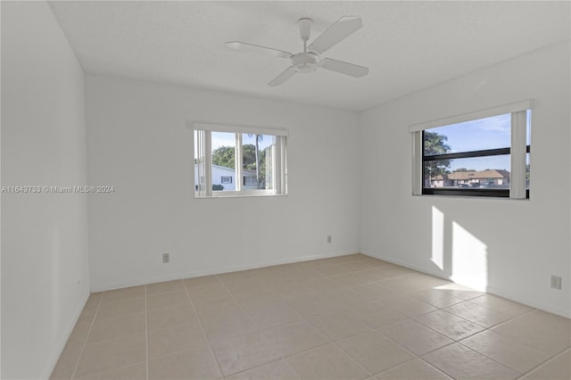 empty room featuring light tile patterned floors and ceiling fan