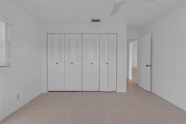 unfurnished bedroom with ceiling fan, a closet, and light tile patterned floors