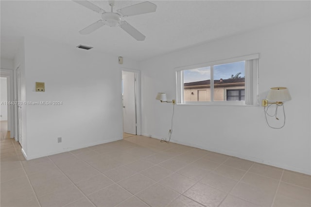 empty room with light tile patterned floors and ceiling fan