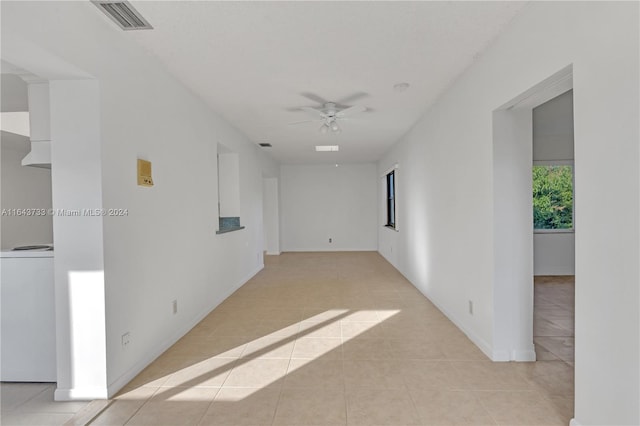 spare room featuring ceiling fan, light tile patterned floors, and washer / dryer