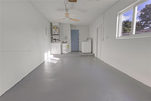 garage featuring ceiling fan, washing machine and dryer, and electric water heater