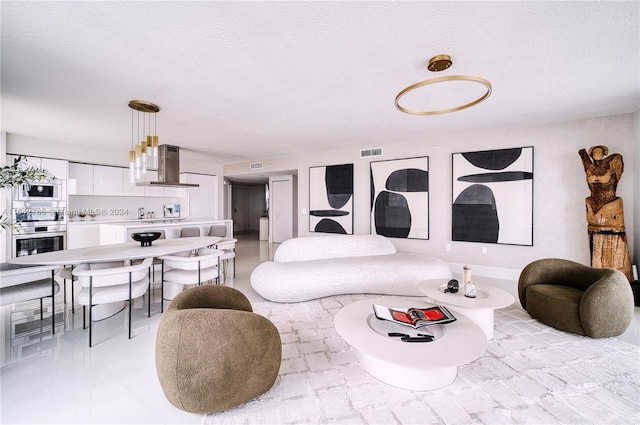 tiled living room featuring a textured ceiling