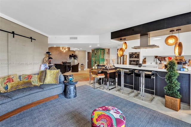 tiled living room featuring bar area and a barn door