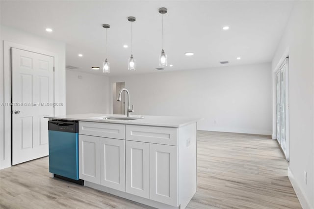 kitchen featuring white cabinetry, stainless steel dishwasher, a kitchen island with sink, and sink