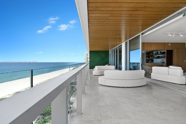 balcony with a water view and a view of the beach