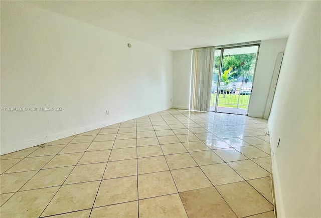 unfurnished room featuring light tile patterned floors and a wall of windows