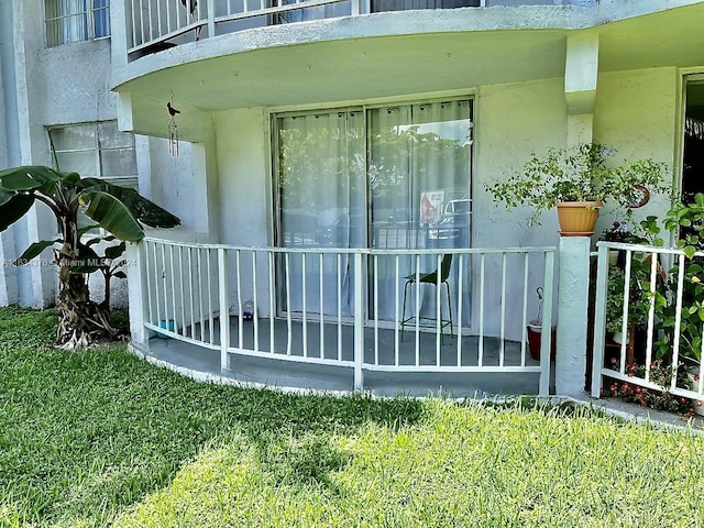 exterior space with a balcony and a lawn