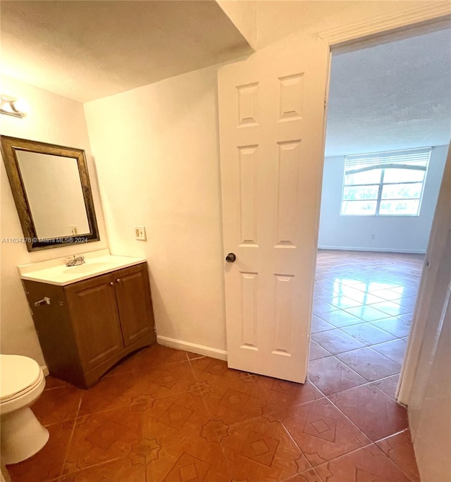 bathroom featuring tile patterned floors, vanity, and toilet