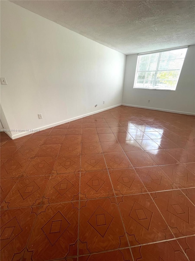 unfurnished room featuring a textured ceiling