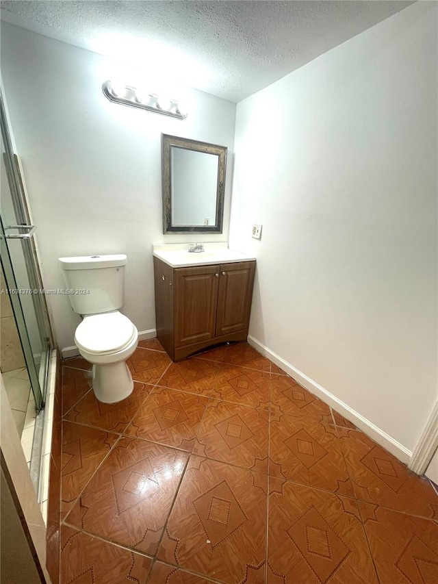 bathroom featuring tile patterned flooring, toilet, a textured ceiling, and vanity