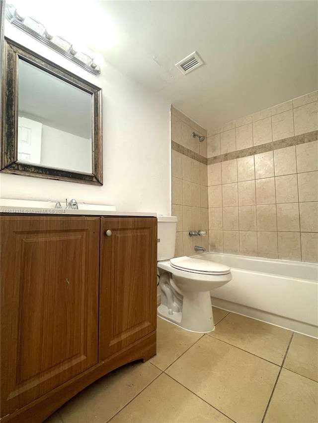 full bathroom featuring tile patterned flooring, tiled shower / bath combo, and toilet