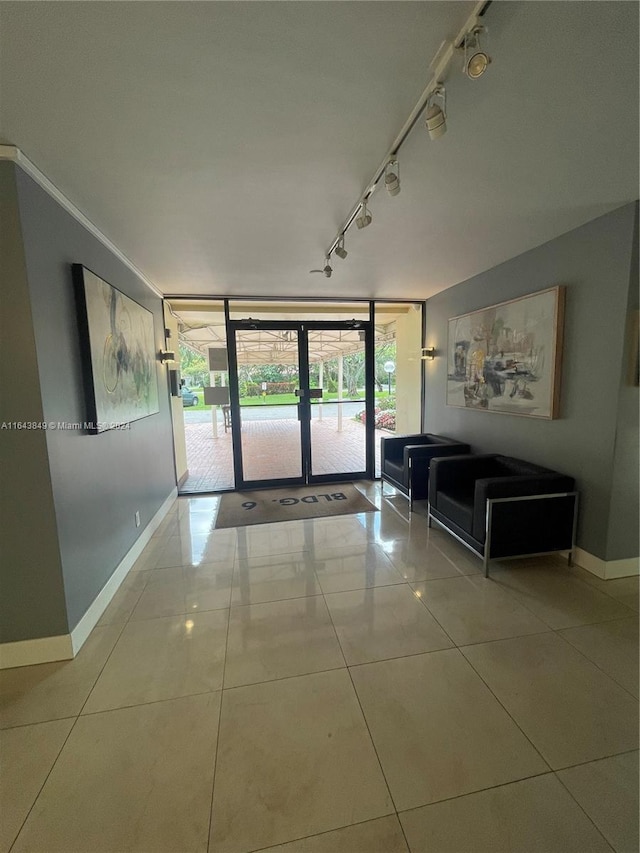 unfurnished living room featuring expansive windows, track lighting, french doors, and tile patterned floors