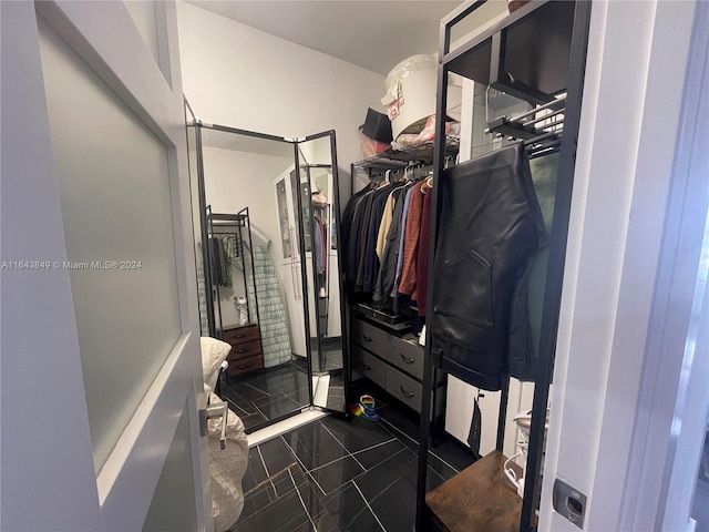 walk in closet featuring dark tile patterned floors