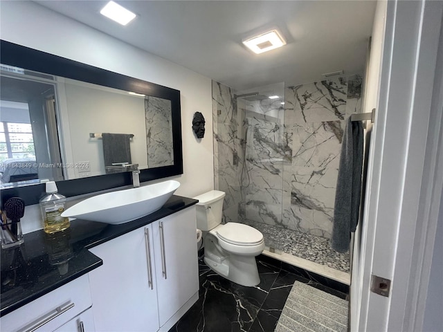 bathroom featuring tile patterned flooring, toilet, tiled shower, and vanity