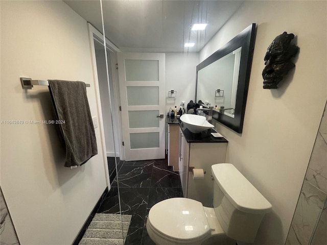 bathroom with toilet, tile patterned flooring, and vanity