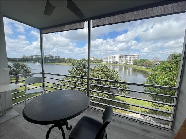 balcony featuring ceiling fan and a water view