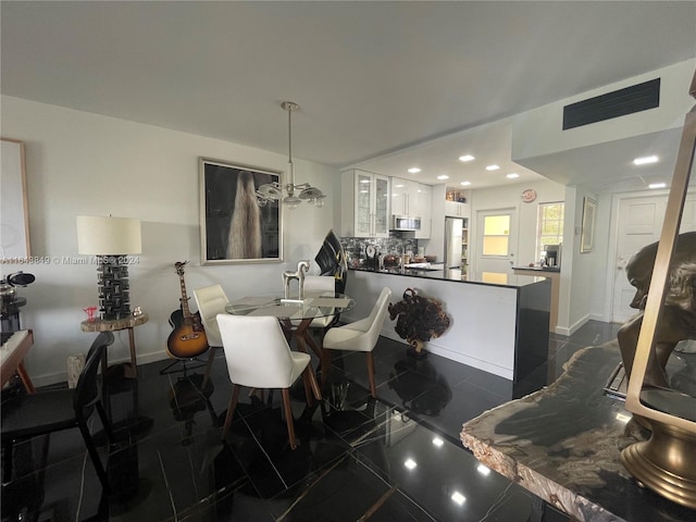 tiled dining space with a notable chandelier