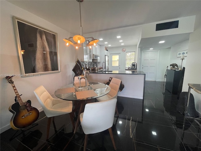 dining space with sink and dark tile patterned floors