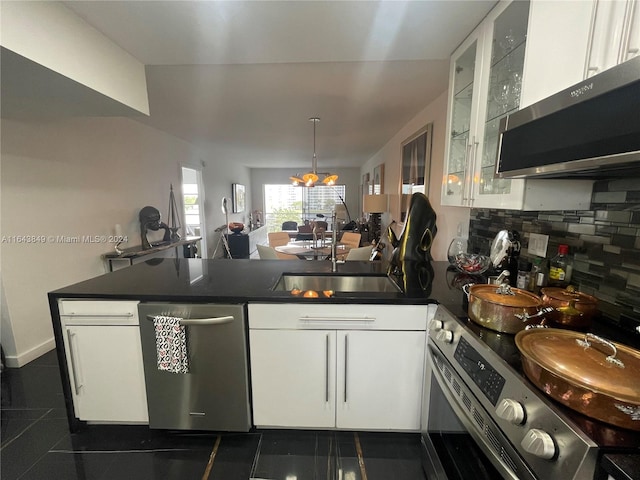 kitchen with sink, white cabinets, dark tile patterned flooring, and stainless steel appliances