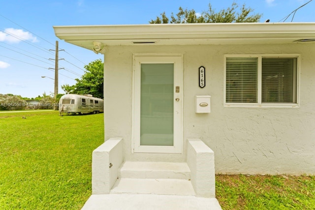 doorway to property featuring a yard