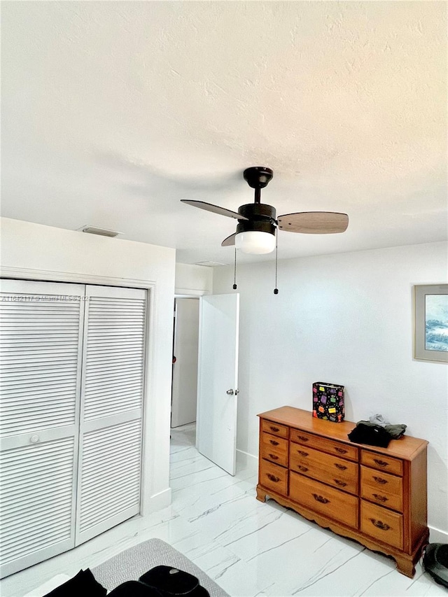 bedroom featuring ceiling fan and a closet