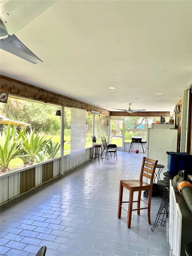 sunroom / solarium featuring ceiling fan