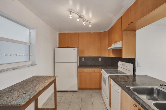 kitchen featuring rail lighting, sink, tasteful backsplash, light tile patterned floors, and white appliances