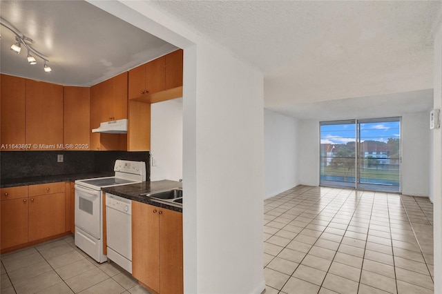 kitchen featuring backsplash, light tile patterned floors, white appliances, floor to ceiling windows, and a textured ceiling