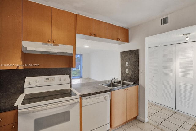 kitchen with backsplash, white appliances, sink, and light tile patterned floors