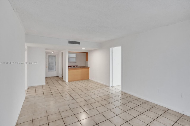 tiled spare room with a textured ceiling