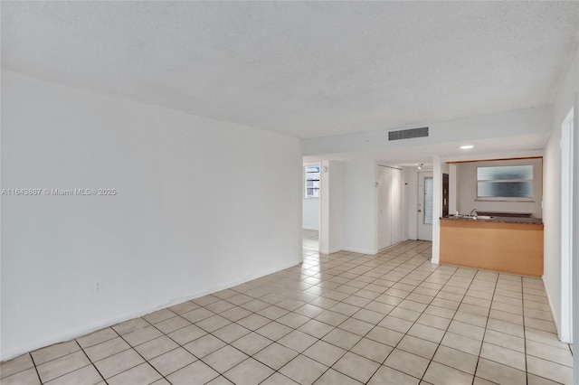 tiled spare room featuring a textured ceiling