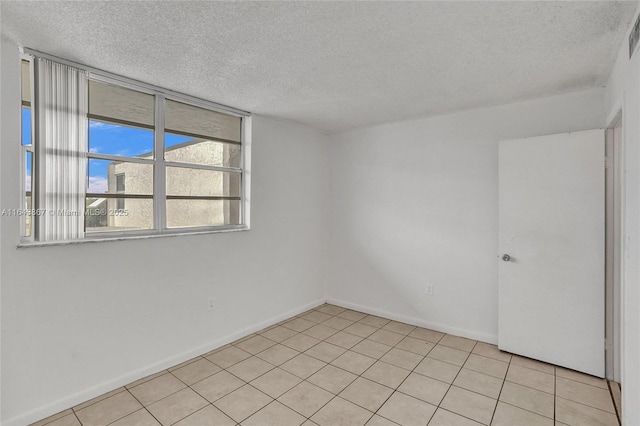 unfurnished room featuring light tile patterned floors and a textured ceiling