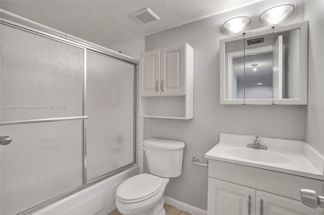 full bathroom featuring vanity, combined bath / shower with glass door, and toilet