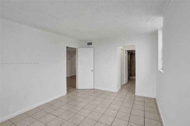 tiled spare room with a textured ceiling