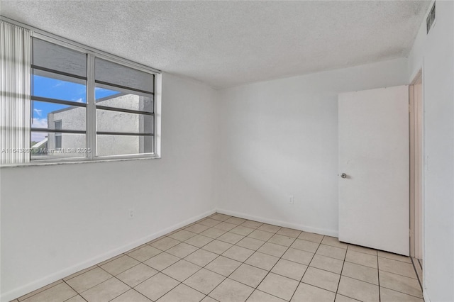 unfurnished room with light tile patterned floors and a textured ceiling