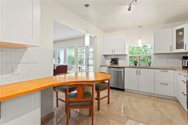 kitchen with sink, tasteful backsplash, dishwasher, and a healthy amount of sunlight