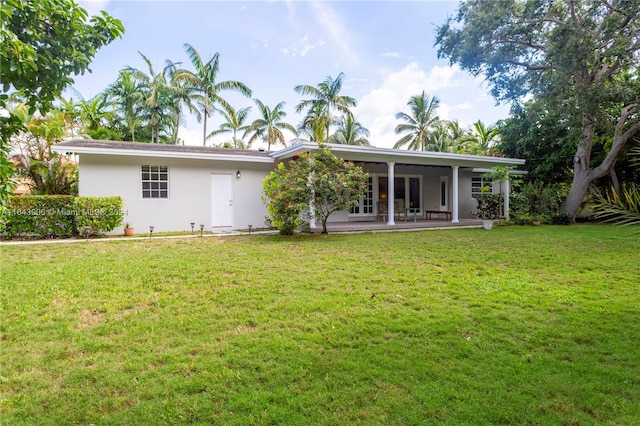 back of property featuring a lawn