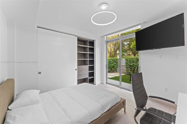 bedroom featuring floor to ceiling windows, a closet, multiple windows, and access to exterior