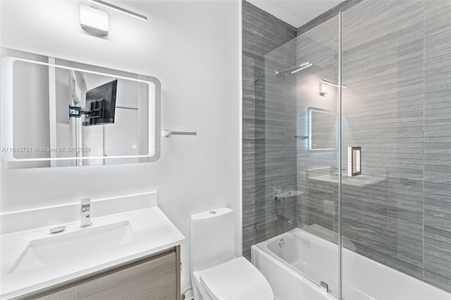 full bathroom with toilet, vanity, and enclosed tub / shower combo