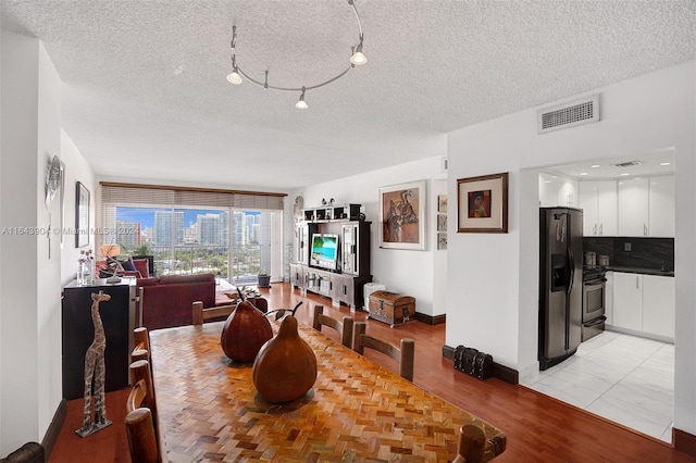 dining area featuring a textured ceiling and light parquet flooring