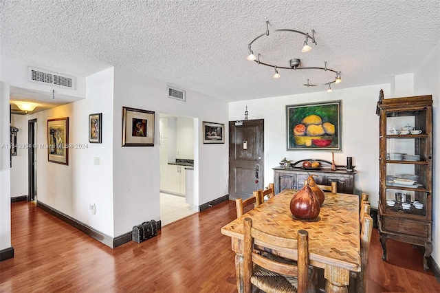 dining space featuring a textured ceiling, tile patterned flooring, and track lighting