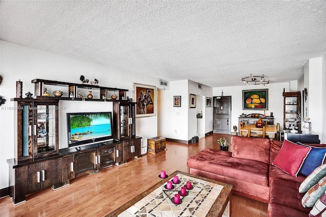 living room featuring hardwood / wood-style flooring, a textured ceiling, and track lighting