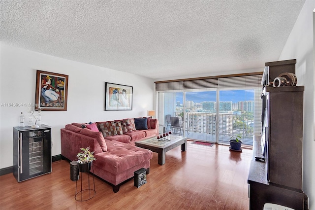 living room featuring a textured ceiling, wine cooler, and hardwood / wood-style flooring