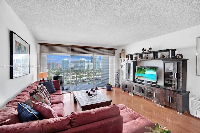 living room with a textured ceiling, a healthy amount of sunlight, and hardwood / wood-style floors