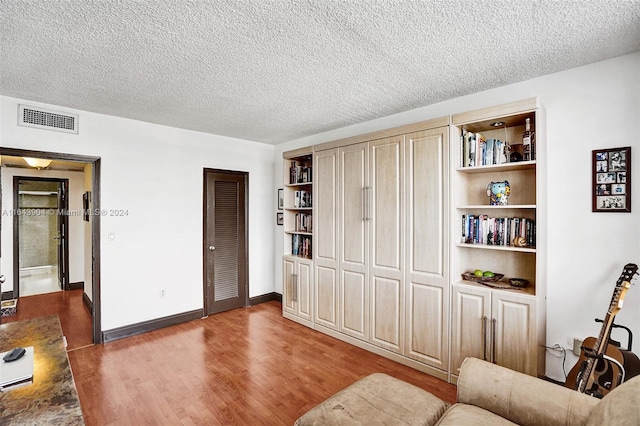 living room with a textured ceiling and wood-type flooring