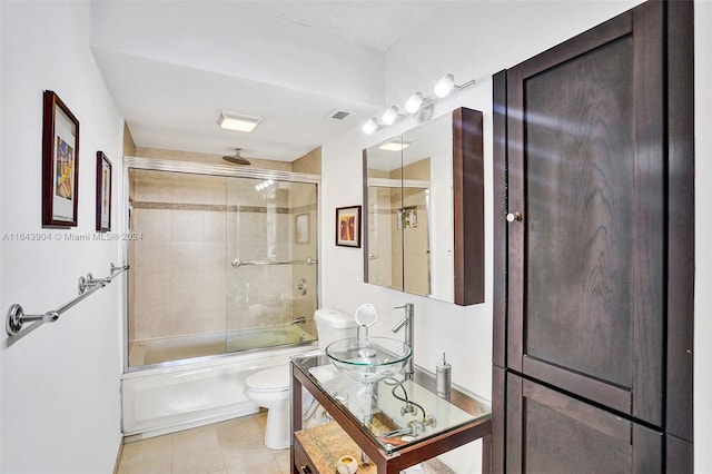 full bathroom featuring tile patterned flooring, toilet, shower / bath combination with glass door, and vanity