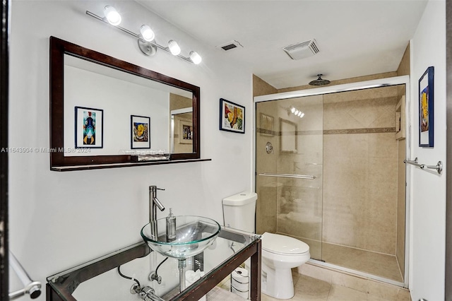 bathroom with tile patterned floors, an enclosed shower, sink, and toilet